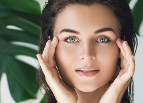 Woman touching her face after eye rejuvenation treatments