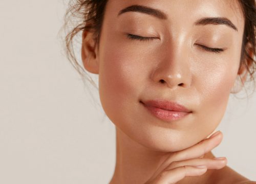 Woman with her eyes closed, touching her chin