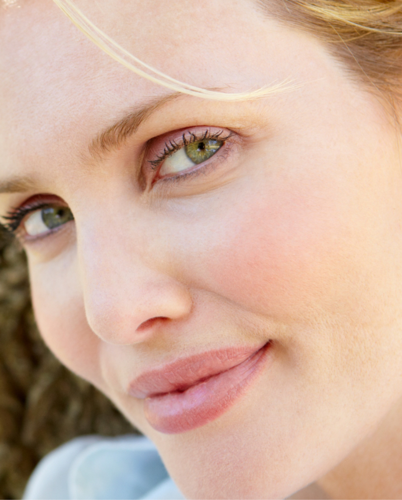 Close-up on a blonde woman's green eyes