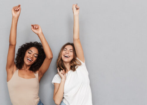 Portrait of two happy young women dancing